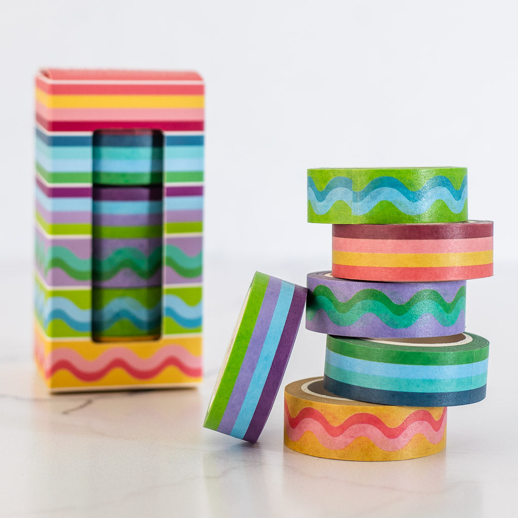 Image of colorful striped and squiggle washi tape stacked in a pile with product box in background