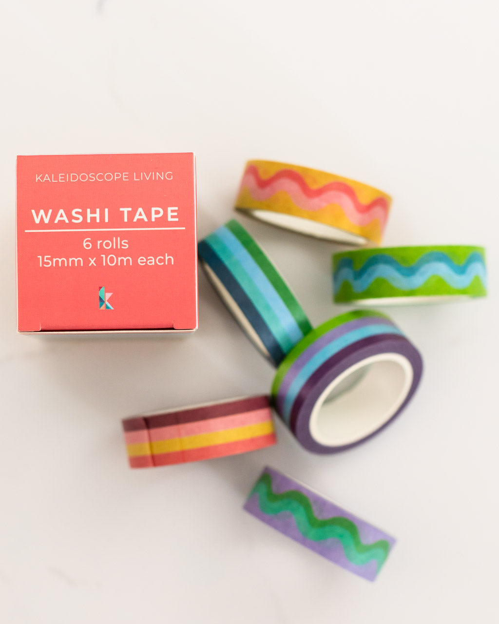 image of colorful striped and squiggle washi tape laying on white table with product box beside it