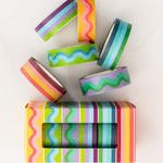 image of colorful striped and squiggle washi tape laying on white marble surface beside product box