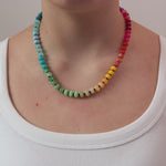 Round beaded necklace in rainbow gradient with gold clasp.  