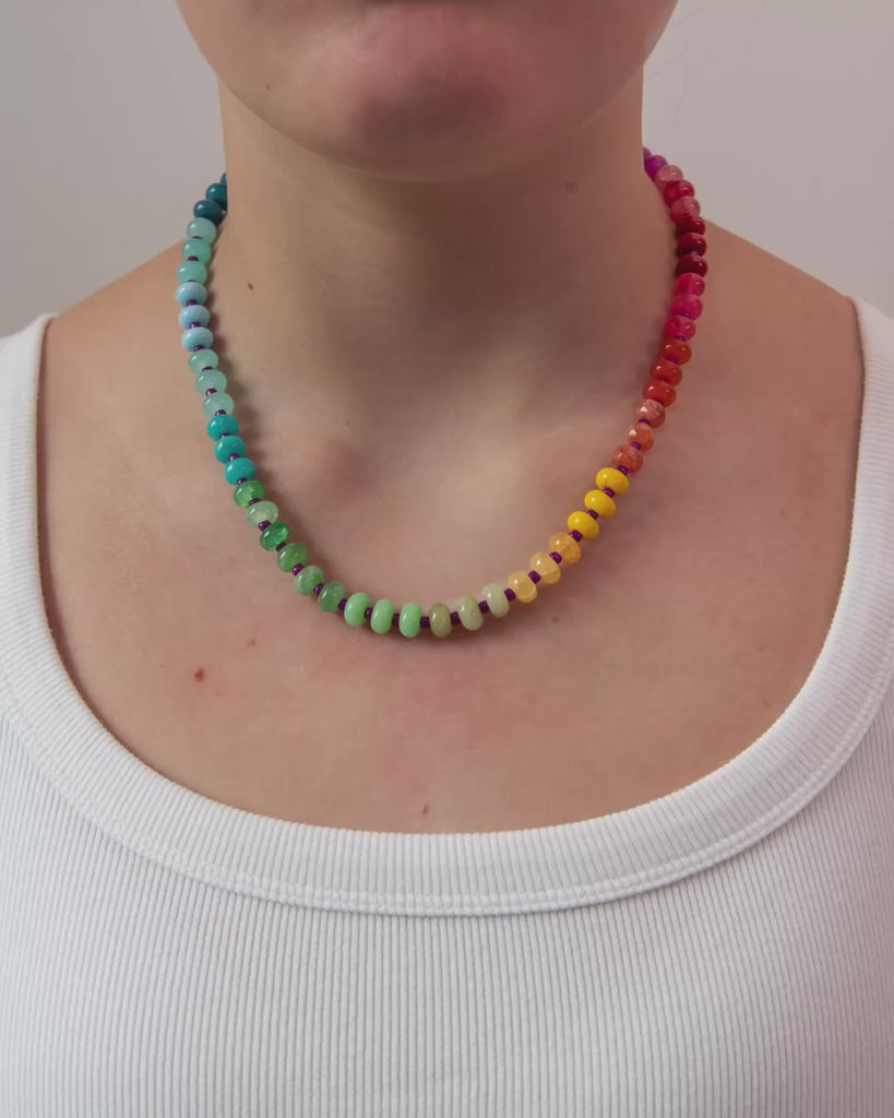 Round beaded necklace in rainbow gradient with gold clasp.  