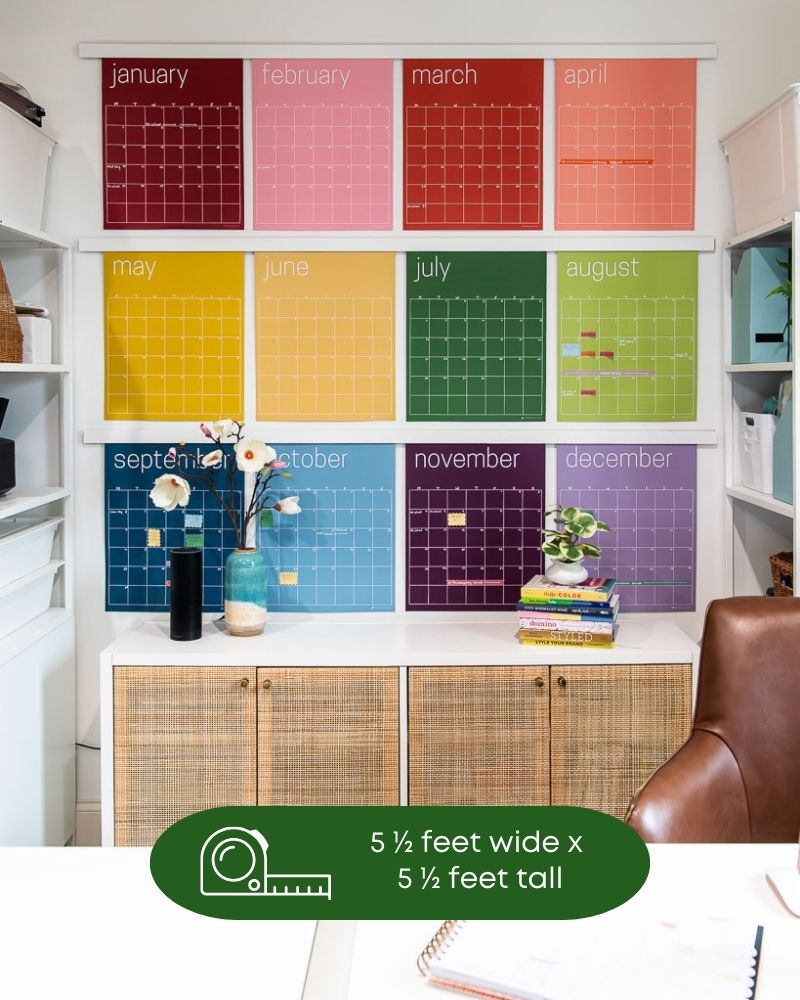 image of large reusable rainbow wall calendar hanging in home office with text overlay that showing the measurement of the wall space required for the shown hanging configuration of 5 1/2 feet wide by 5 1/2 feet tall