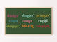 A digital artwork displayed on a television, featuring the names of reindeer in colorful typography and green background, hanging on a wall.