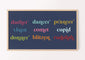 A digital artwork displayed on a television, featuring the names of reindeer in colorful typography and navy background, hanging on a wall.
