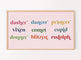A digital artwork displayed on a television, featuring the names of reindeer in colorful typography and pink background, hanging on a wall.